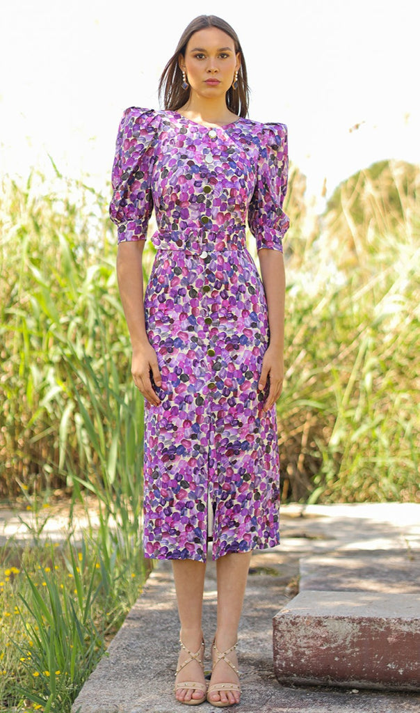 Straight midi dress with round neckline, puffed and elbow-length sleeves, center seam with sewn buttons and belt, and front slit in the skirt. Made with mauve printed jacquard fabric.