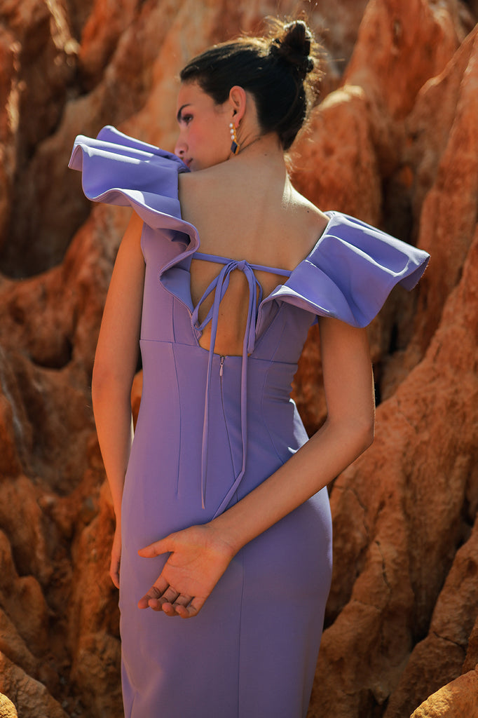 Fitted midi dress with draping in the center and opening in the leg. V-neckline with large ruffle and lacing in the back.