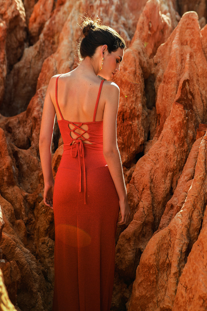 Long, narrow, Lurex knit dress with cut out cut under the chest and draped skirt. Open back with braided closure.